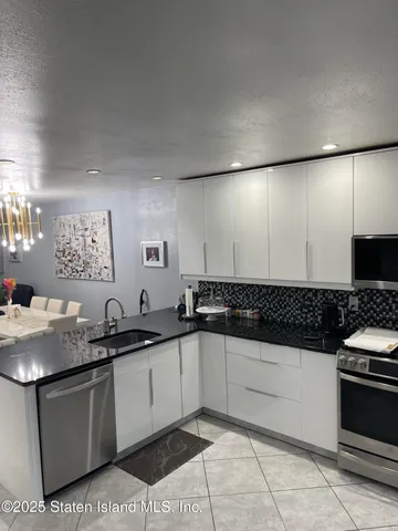 a kitchen with granite countertop a sink and a stove top oven