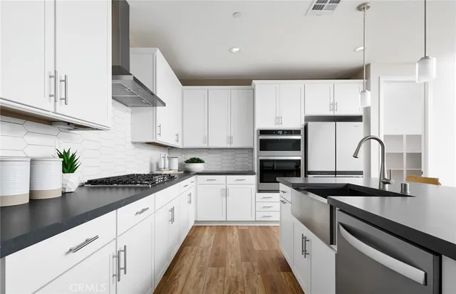 a kitchen with kitchen island granite countertop a sink stainless steel appliances and cabinets