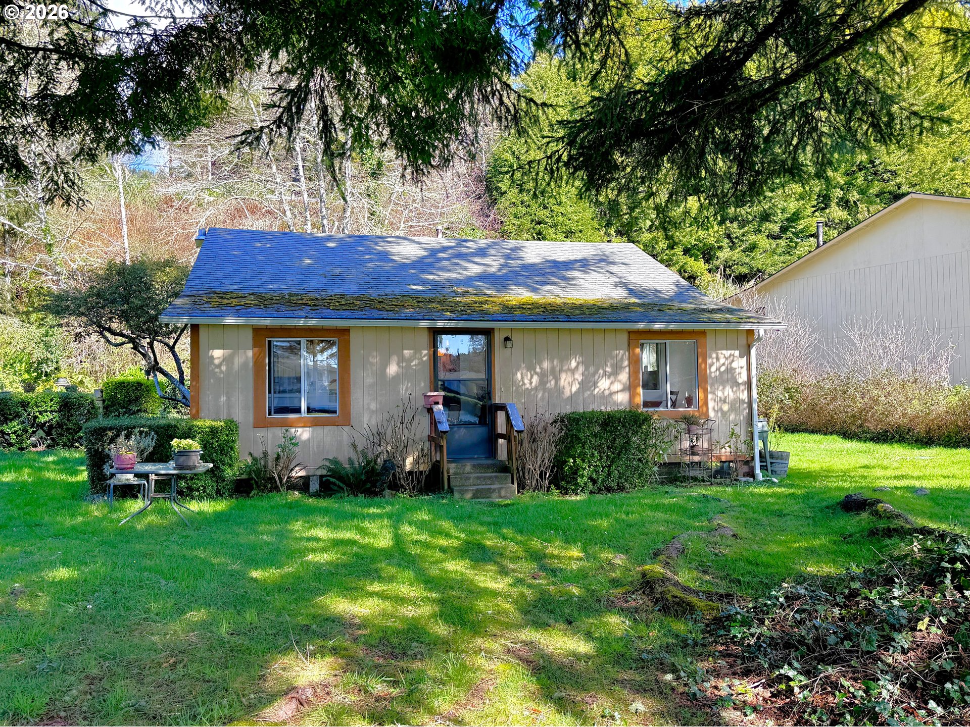 99270 Winchuck River Road Brookings, OR 97415 - Photo 5 of 41 a front view of a house with garden and porch