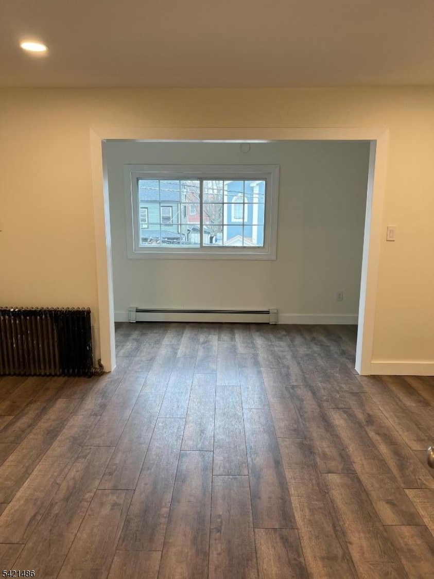 227 Palmer Street, Unit 1 Elizabeth, NJ 07202 - Photo 5 of 7 an empty room with wooden floor and windows