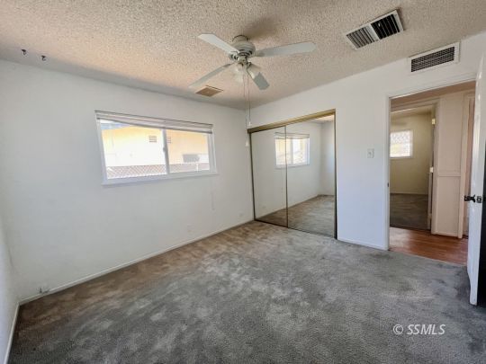 250 Peg Street Ridgecrest, CA 93555 - Photo 11 of 16 an empty room with chandelier fan and windows