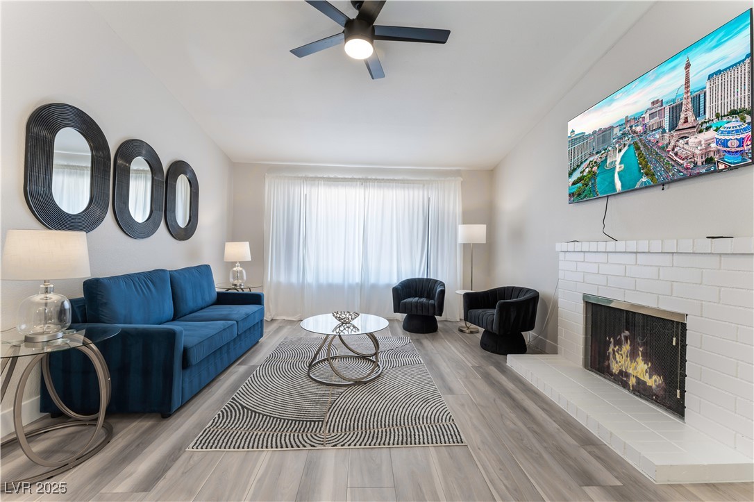 Undisclosed Address Las Vegas, NV 89119 - Photo 2 of 11 Living room featuring wood finished floors, a fire