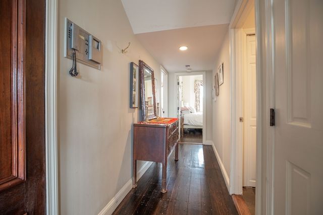 a view of a hallway with wooden floor and furniture
