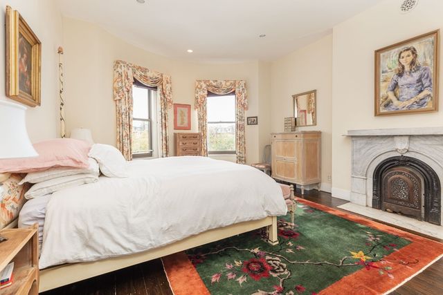 a bed sitting in a bedroom next to a window with a kitchen