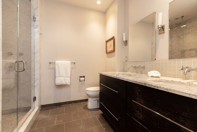 a bathroom with a granite countertop sink toilet and shower