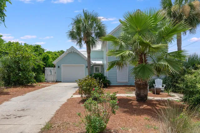 a view of a house with a yard and palm trees
