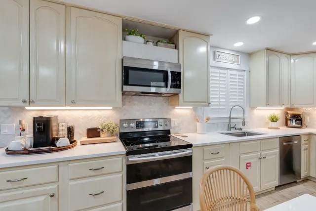 a kitchen with stainless steel appliances granite countertop a stove a sink and a microwave