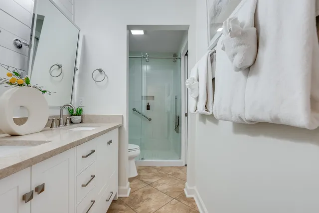 a bathroom with a granite countertop sink mirror and shower
