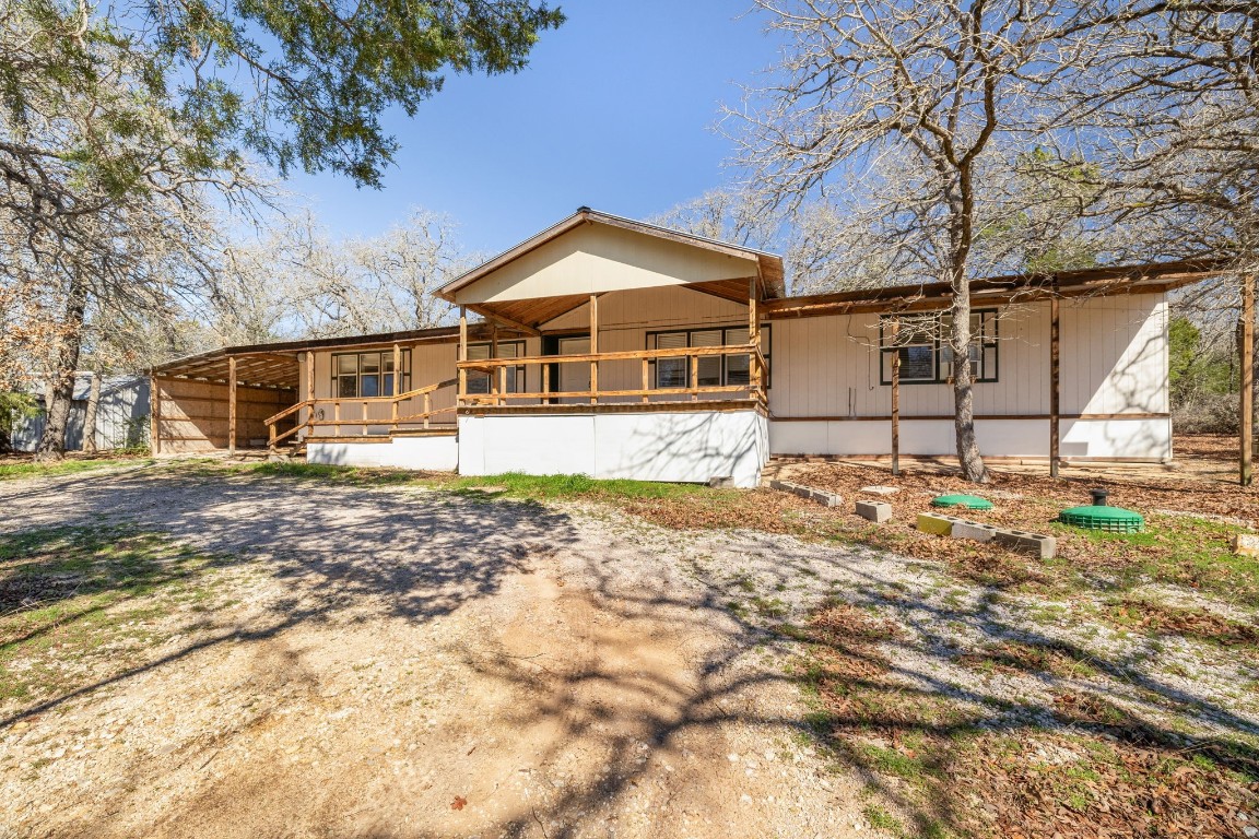 a front view of a house with a yard covered with snow and trees