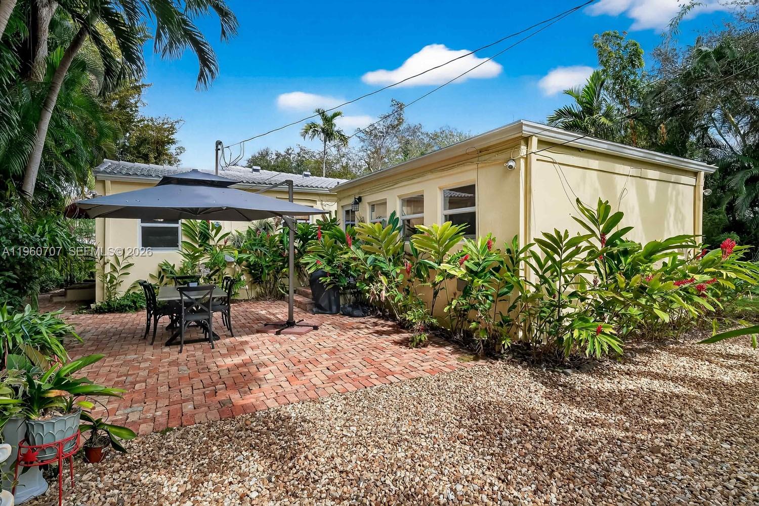 46 Northeast 100th Street Miami Shores, FL 33138 - Photo 7 of 28 a view of a house with garden and lawn chairs