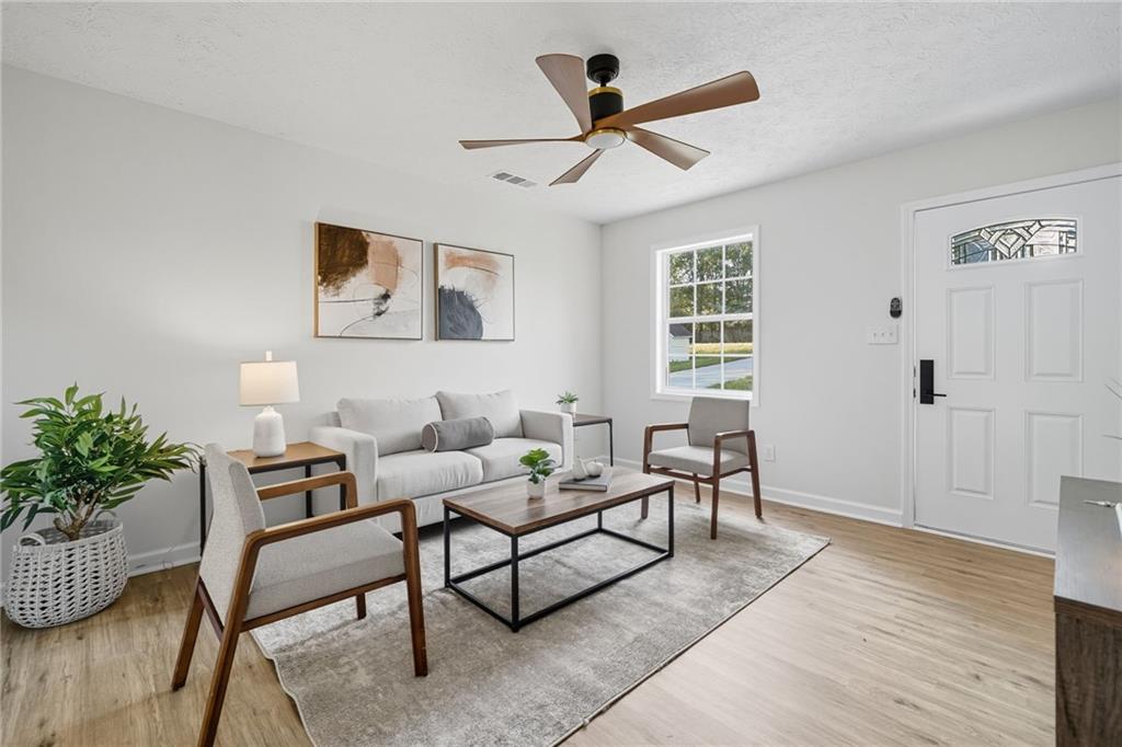 6964 Wheeler Road Lula, GA 30554 - Photo 7 of 27 a living room with furniture and a potted plant