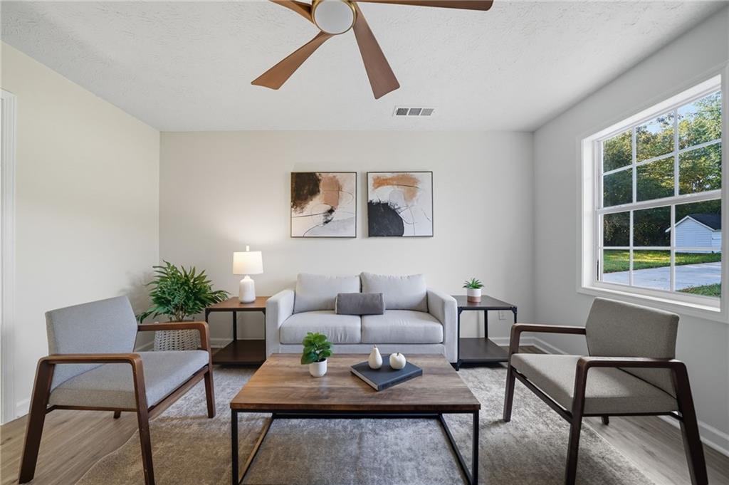 6964 Wheeler Road Lula, GA 30554 - Photo 8 of 27 a living room with furniture and a potted plant