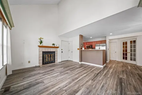 a view of a livingroom with wooden floor and a fireplace