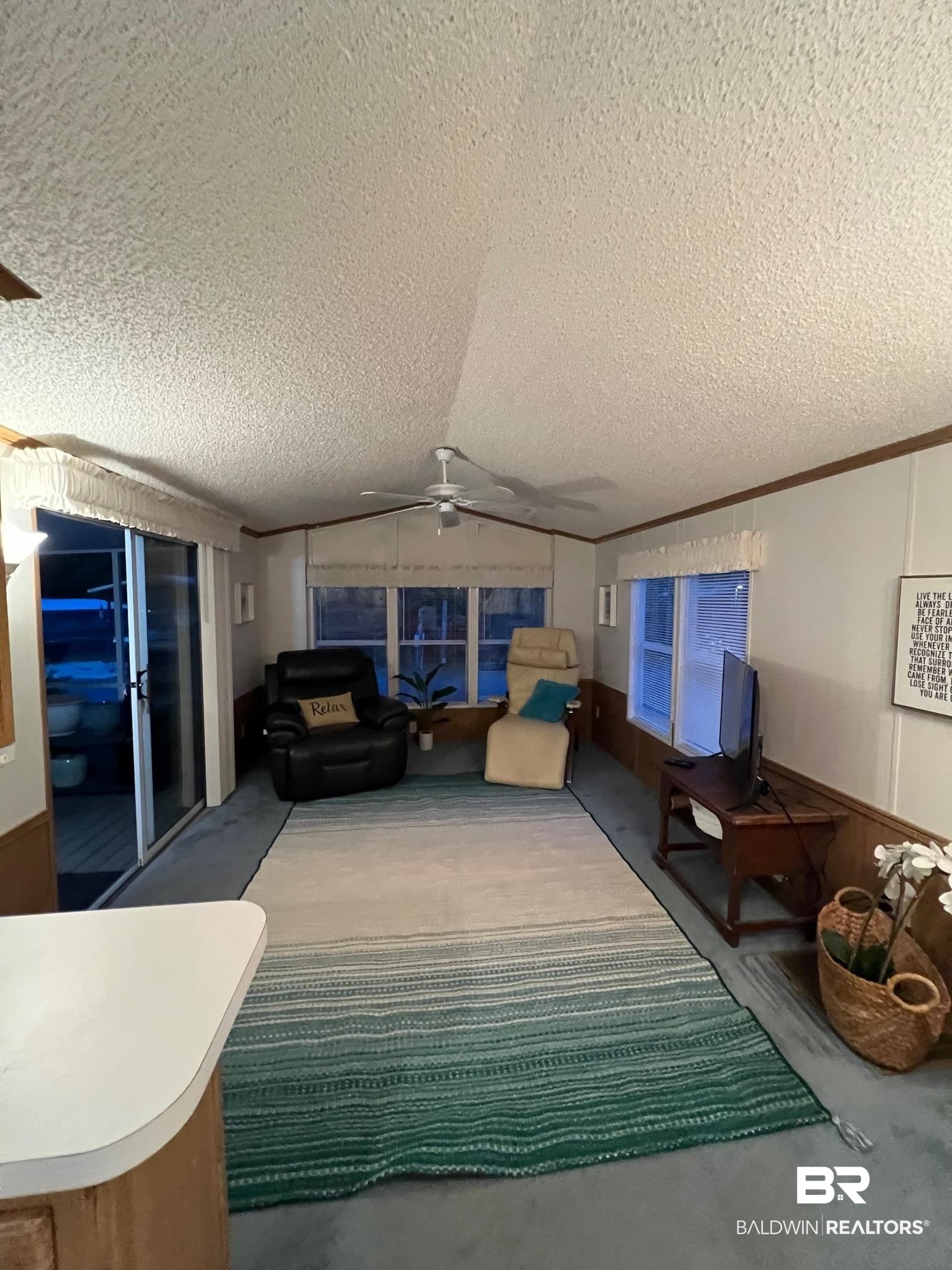 518 Elberta Loop Lillian, AL 36549 - Photo 6 of 38 Living room with lofted ceiling, crown molding, carpet floors, and a ceiling fan