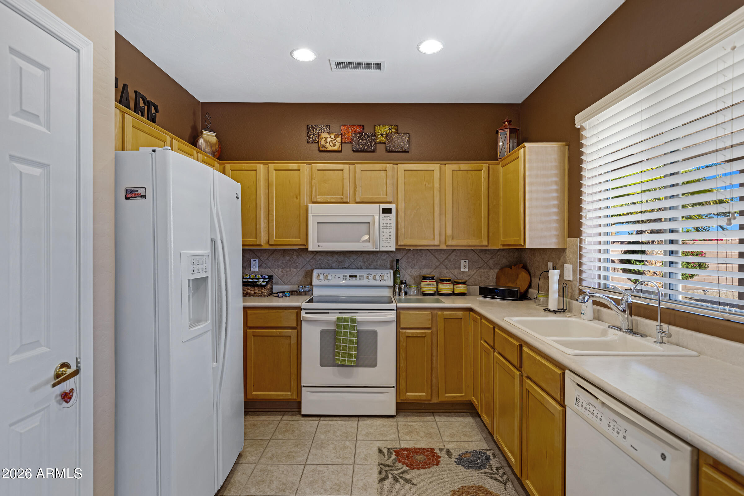 19253 North Hunters Run Surprise, AZ 85387 - Photo 13 of 30 a kitchen with a sink stove and refrigerator