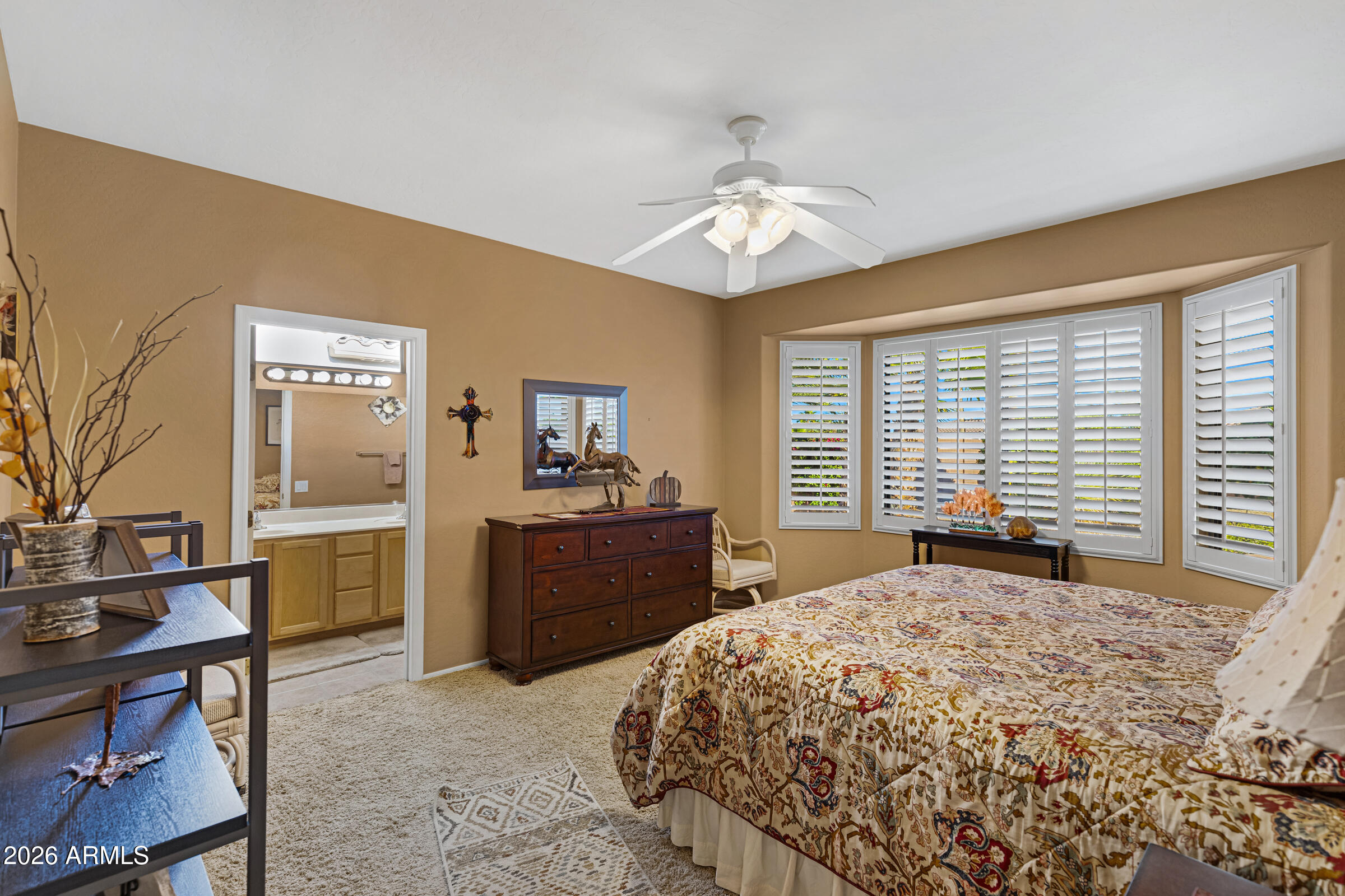 19253 North Hunters Run Surprise, AZ 85387 - Photo 18 of 30 a bedroom with a large bed and a chandelier