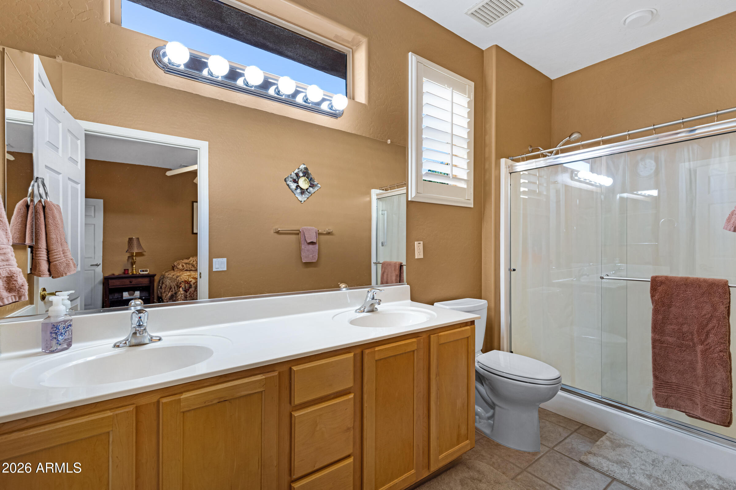 19253 North Hunters Run Surprise, AZ 85387 - Photo 21 of 30 a bathroom with a double vanity sink toilet and a mirror