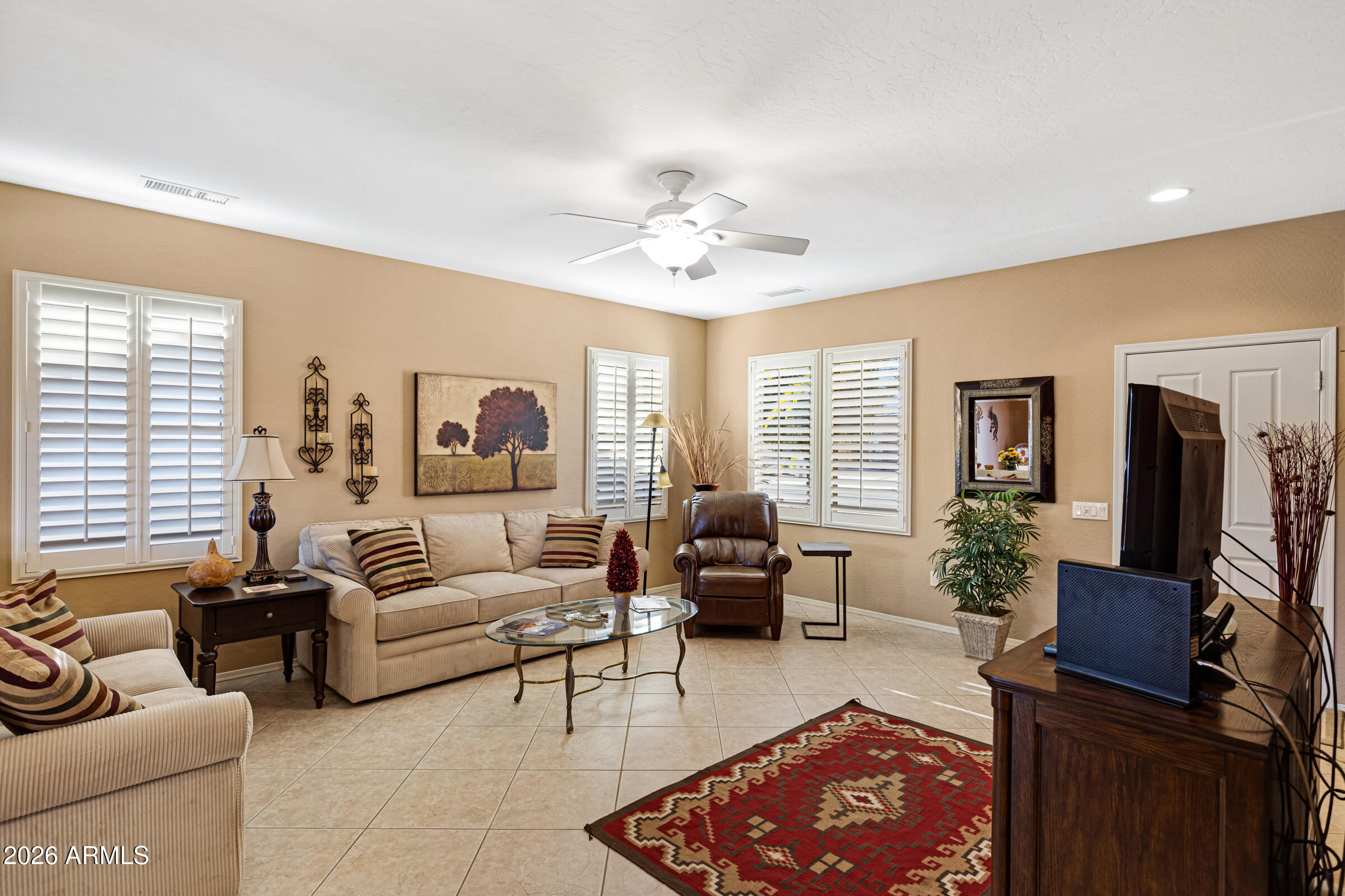 19253 North Hunters Run Surprise, AZ 85387 - Photo 6 of 30 a living room with furniture ceiling fan and a window