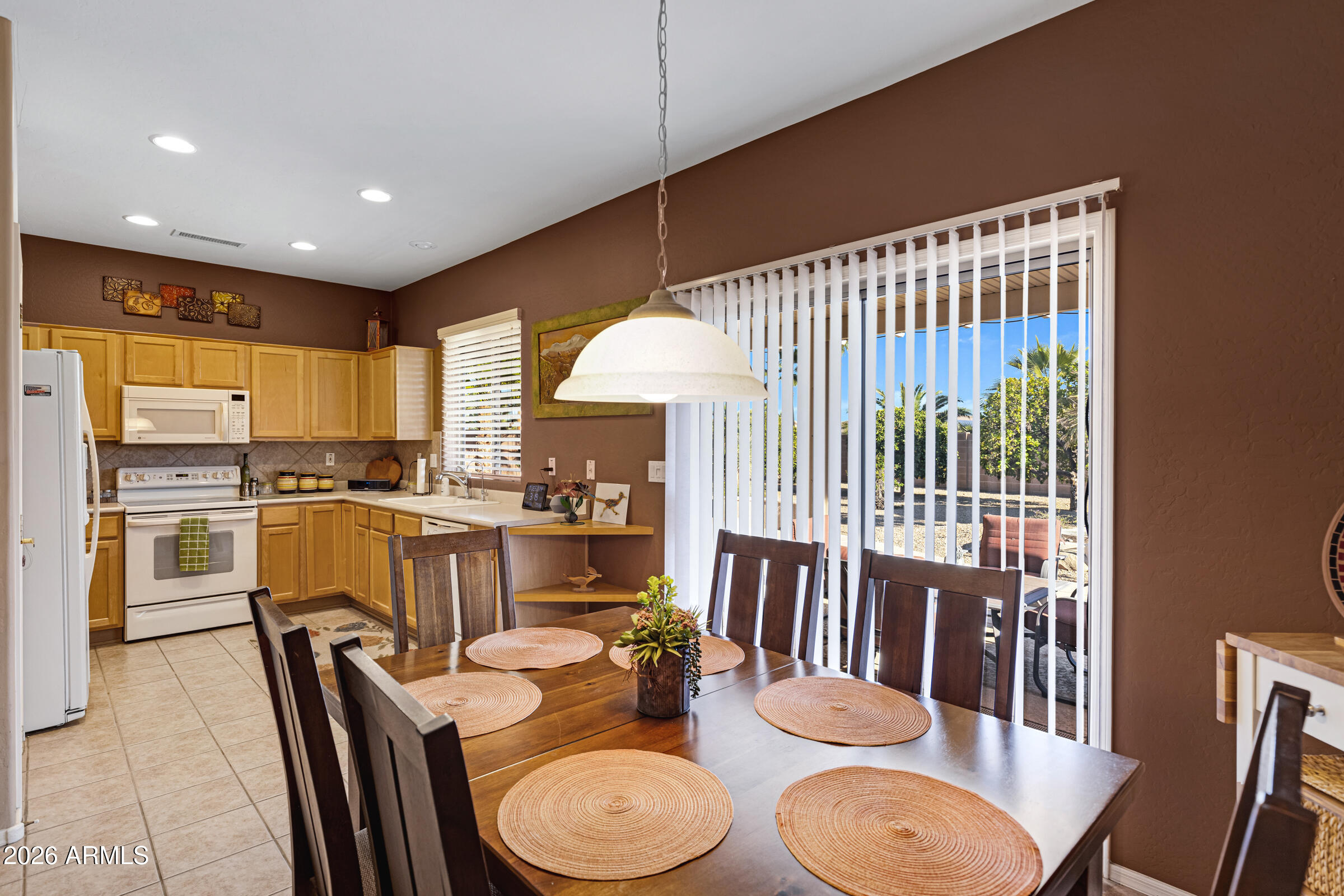 19253 North Hunters Run Surprise, AZ 85387 - Photo 10 of 30 a dining room with furniture a kitchen view and wooden floor