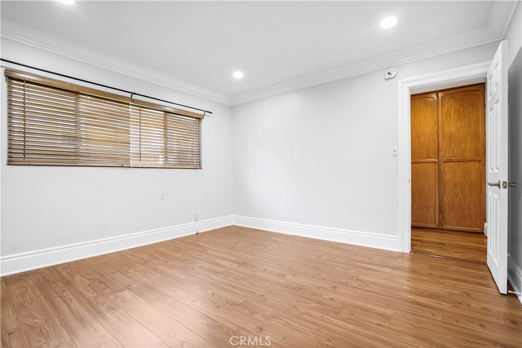 14934 Dickens Street, Unit 15 Sherman Oaks, CA 91403 - Photo 13 of 15 a view of an empty room with wooden floor and a window