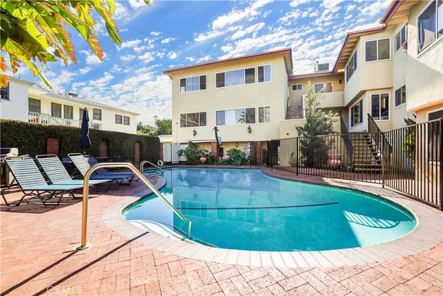 a view of a white building with swimming pool in front of it
