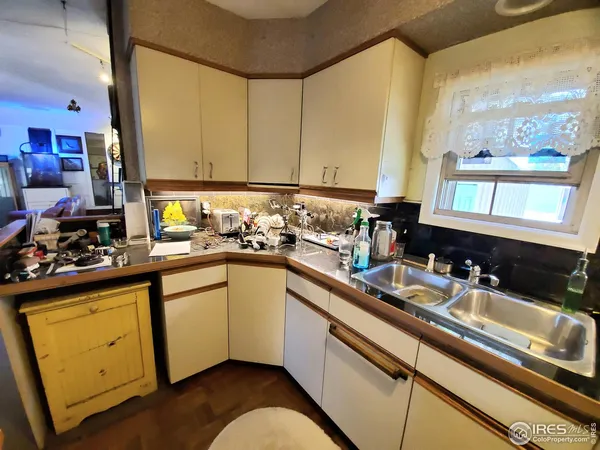 a kitchen with a sink appliances cabinets and a large window
