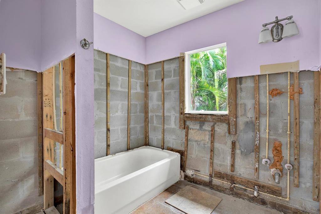 16218 1st Street East Redington Beach, FL 33708 - Photo 9 of 20 a bathroom with a tub shower and window