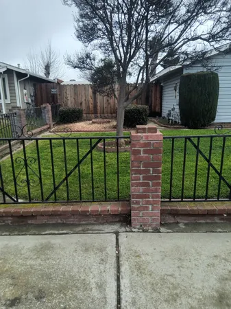 a front view of a house with a yard and fence