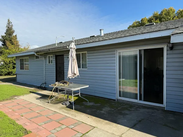 a backyard of a house with table and chairs