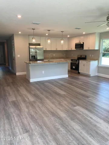 a view of kitchen with kitchen island and stainless steel appliances
