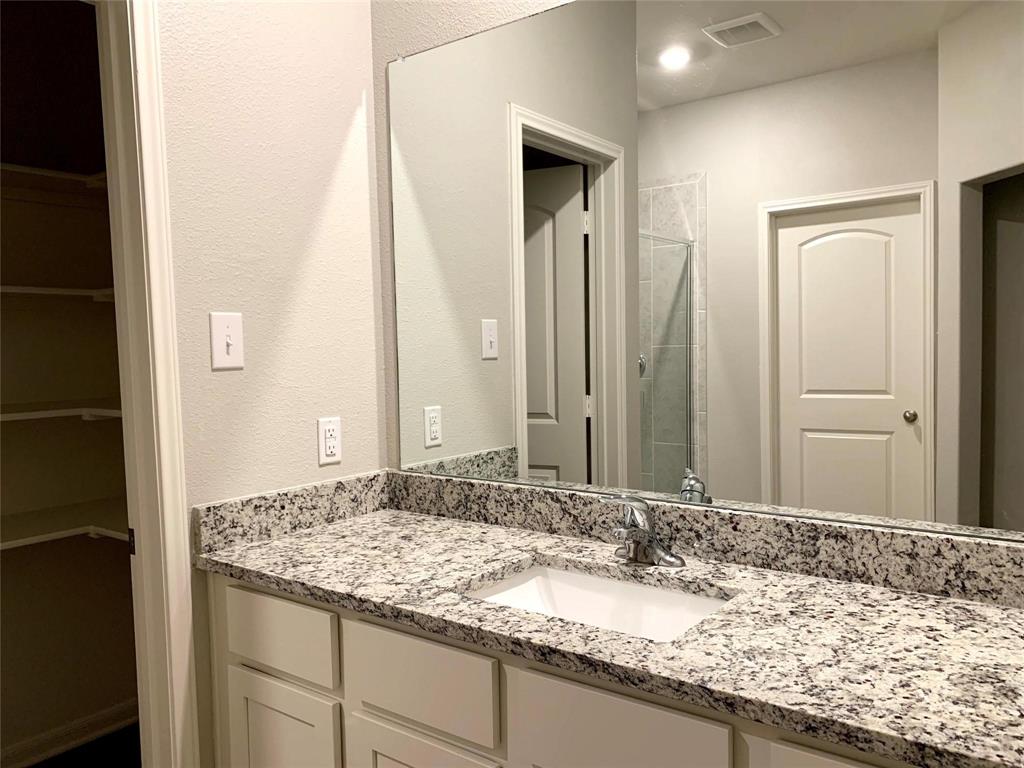 144 Emma Drive Anna, TX 75409 - Photo 23 of 34 a bathroom with a granite countertop sink and a mirror