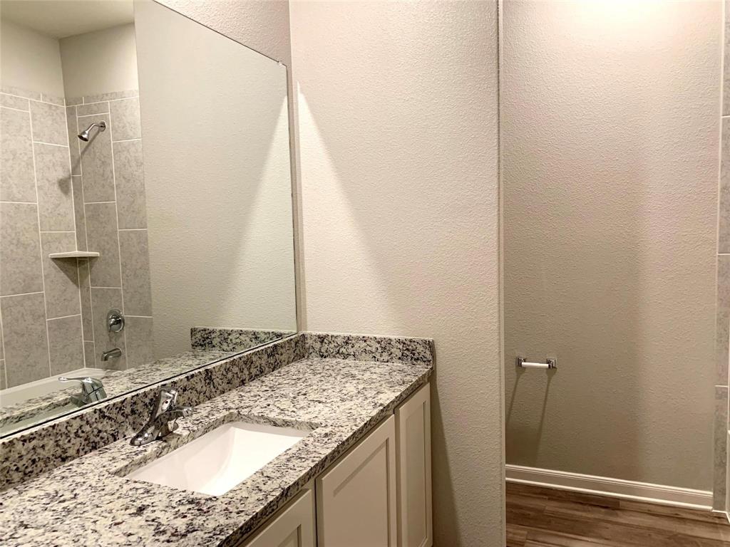 144 Emma Drive Anna, TX 75409 - Photo 26 of 34 a bathroom with a granite countertop sink and a mirror