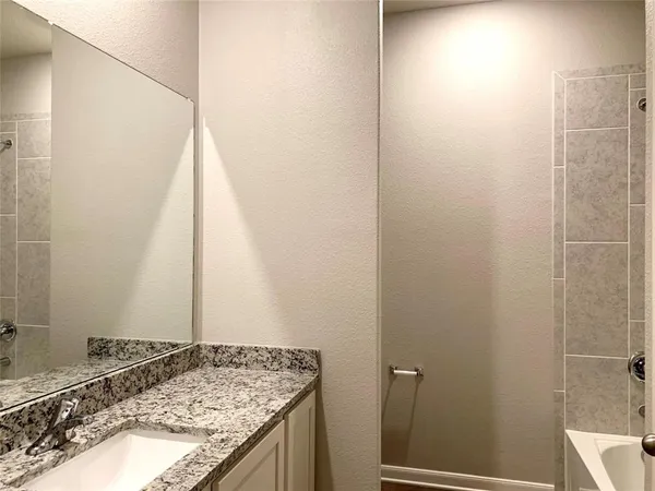 a bathroom with a granite countertop shower and a sink