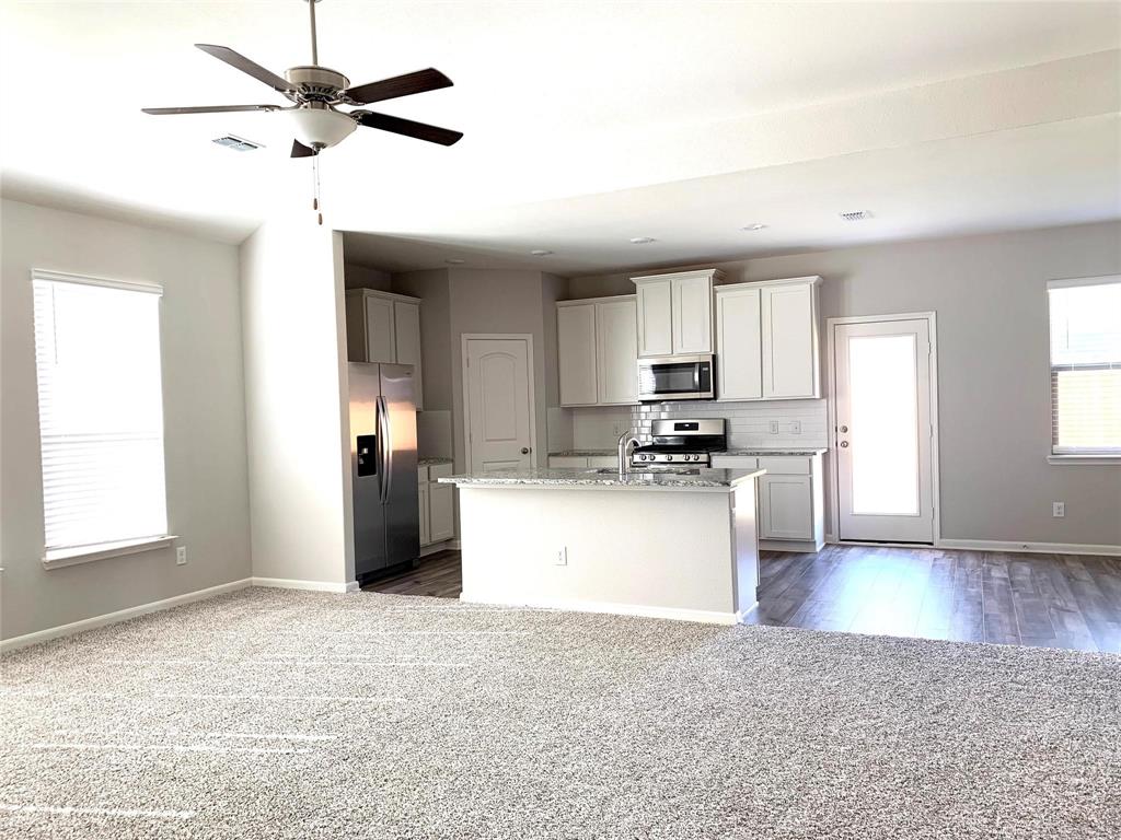 144 Emma Drive Anna, TX 75409 - Photo 5 of 34 a kitchen with stainless steel appliances granite countertop a stove a sink and a refrigerator