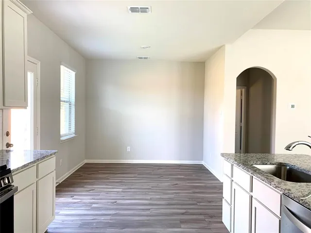 a view of a room with wooden floor and a window