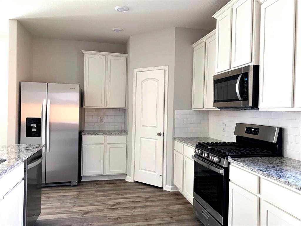 144 Emma Drive Anna, TX 75409 - Photo 8 of 34 a kitchen with a refrigerator stove and microwave