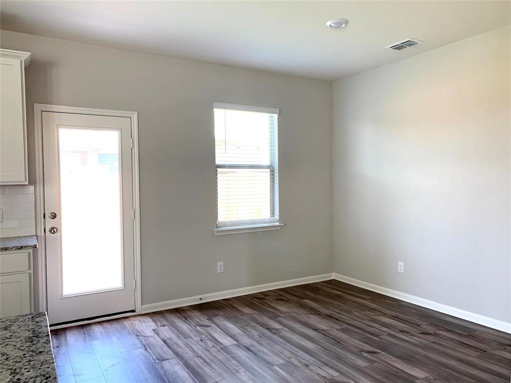 144 Emma Drive Anna, TX 75409 - Photo 10 of 34 an empty room with wooden floor and windows