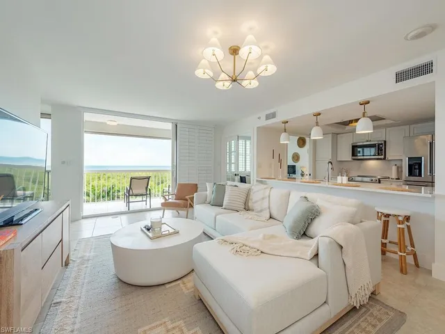 a living room with furniture and a chandelier