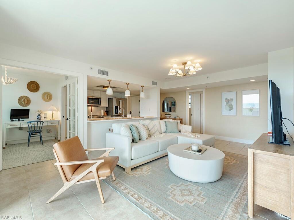 6573 Marissa Loop, Unit 802 Naples, FL 34108 - Photo 2 of 12 a living room with furniture and a chandelier