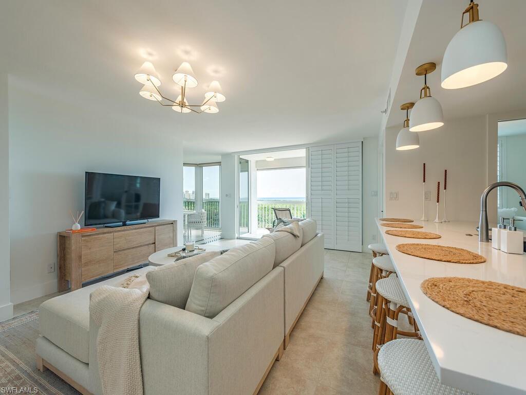 6573 Marissa Loop, Unit 802 Naples, FL 34108 - Photo 3 of 12 a living room with furniture and a flat screen tv