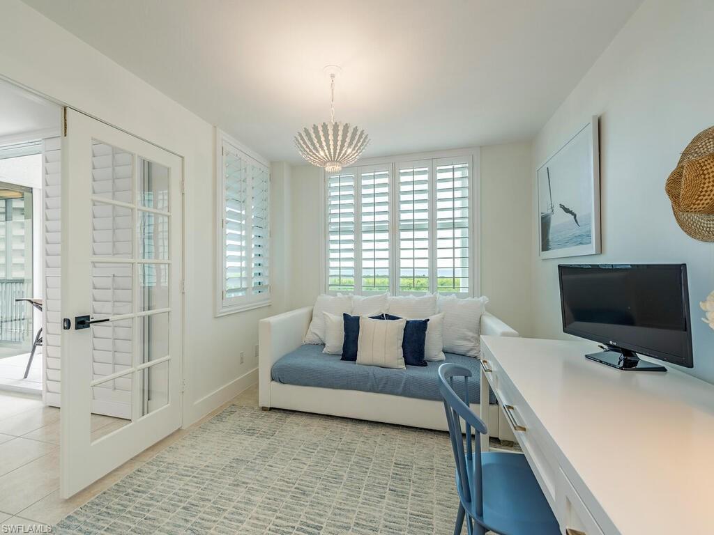 6573 Marissa Loop, Unit 802 Naples, FL 34108 - Photo 7 of 12 a living room with furniture and a flat screen tv