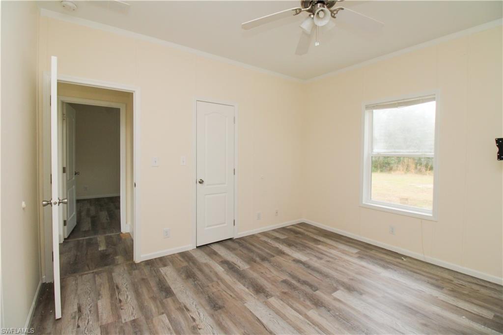 4660 43rd Avenue Northeast Naples, FL 34120 - Photo 22 of 44 an empty room with a window and a chandelier fan
