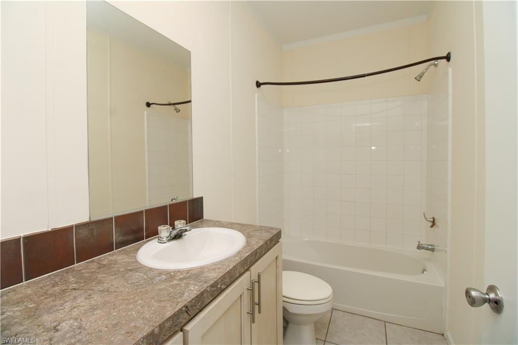 4660 43rd Avenue Northeast Naples, FL 34120 - Photo 23 of 44 a bathroom with a granite countertop sink toilet and shower