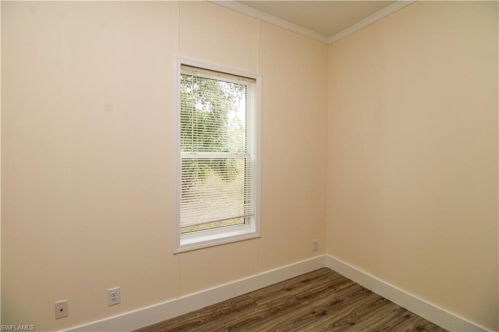 4660 43rd Avenue Northeast Naples, FL 34120 - Photo 30 of 44 an empty room with wooden floor and windows