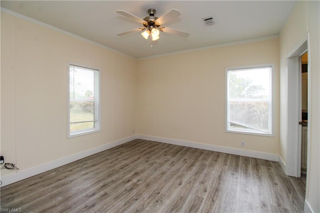 4660 43rd Avenue Northeast Naples, FL 34120 - Photo 32 of 44 a view of empty room with wooden floor and fan