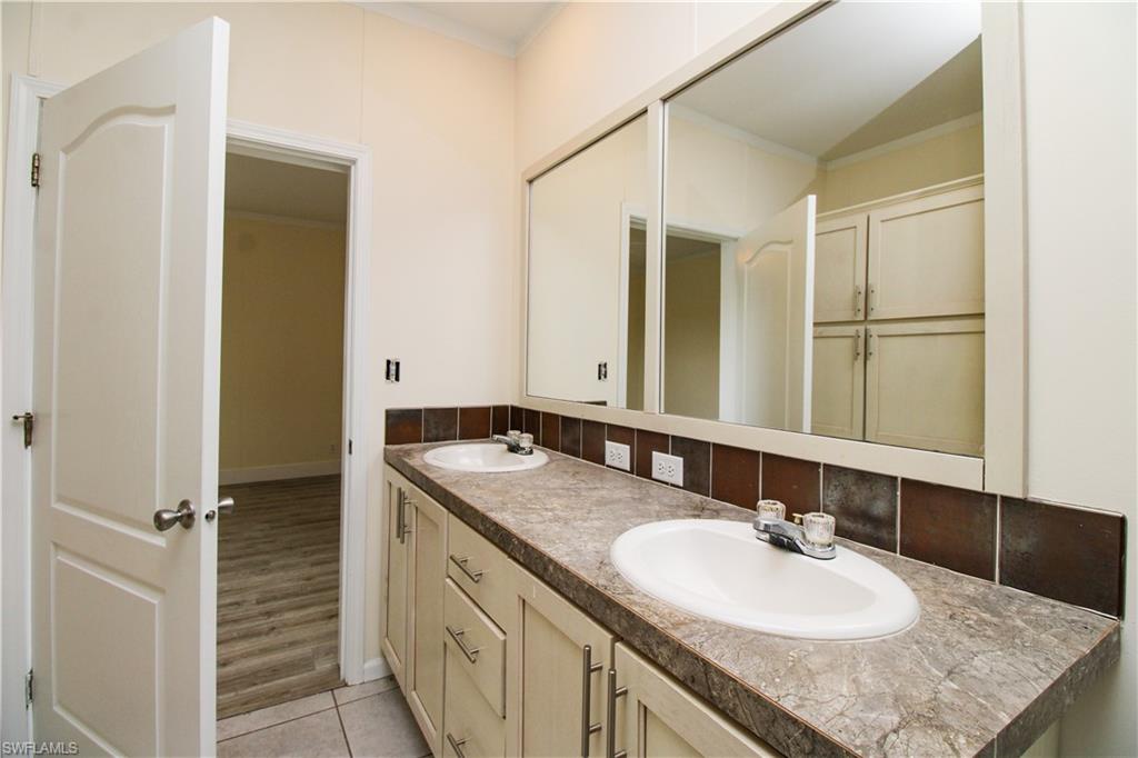 4660 43rd Avenue Northeast Naples, FL 34120 - Photo 36 of 44 a bathroom with a granite countertop sink and a mirror
