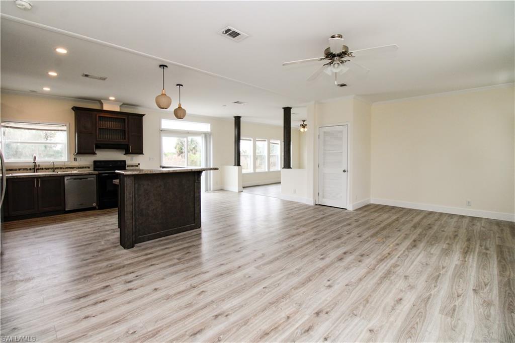 4660 43rd Avenue Northeast Naples, FL 34120 - Photo 38 of 44 an open kitchen with wooden floor and stainless steel appliances