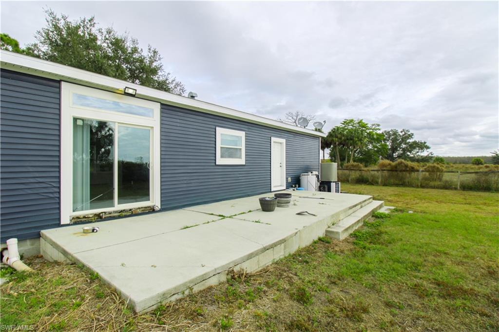 4660 43rd Avenue Northeast Naples, FL 34120 - Photo 7 of 44 a view of a house with a backyard and a yard