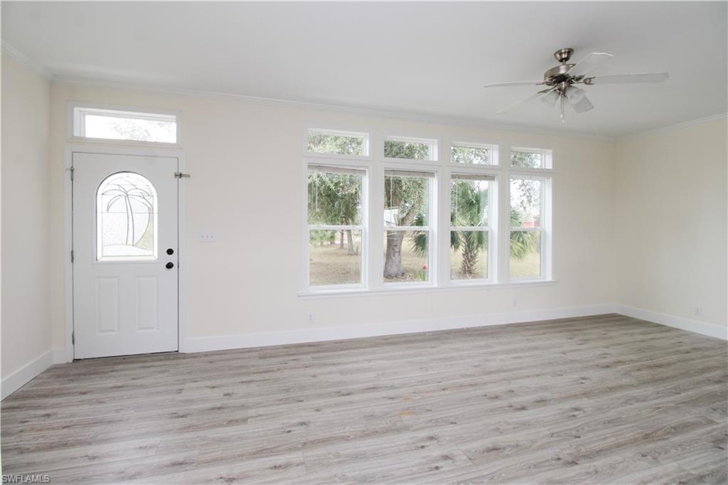 4660 43rd Avenue Northeast Naples, FL 34120 - Photo 10 of 44 a view of an empty room with a window and wooden floor