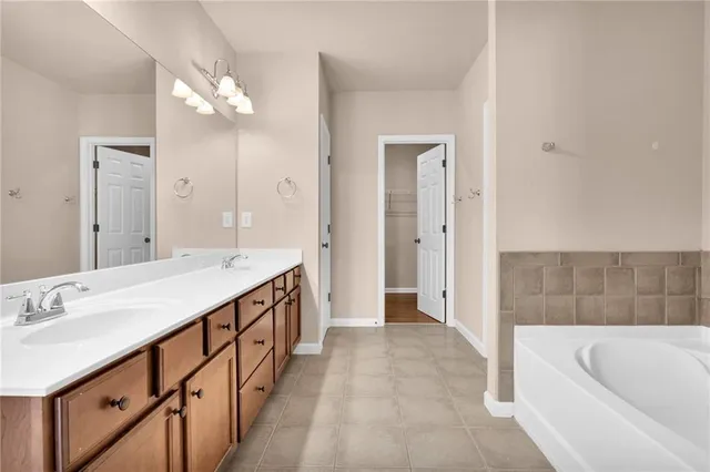 a bathroom with a double vanity sink a mirror a bathtub and